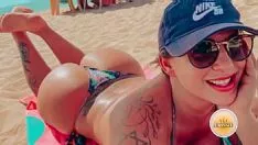 Abspielen Diese Frau sitzt auf einem Liegestuhl am Strand und schmiert ihren ganzen Körper mit Ölen ein
